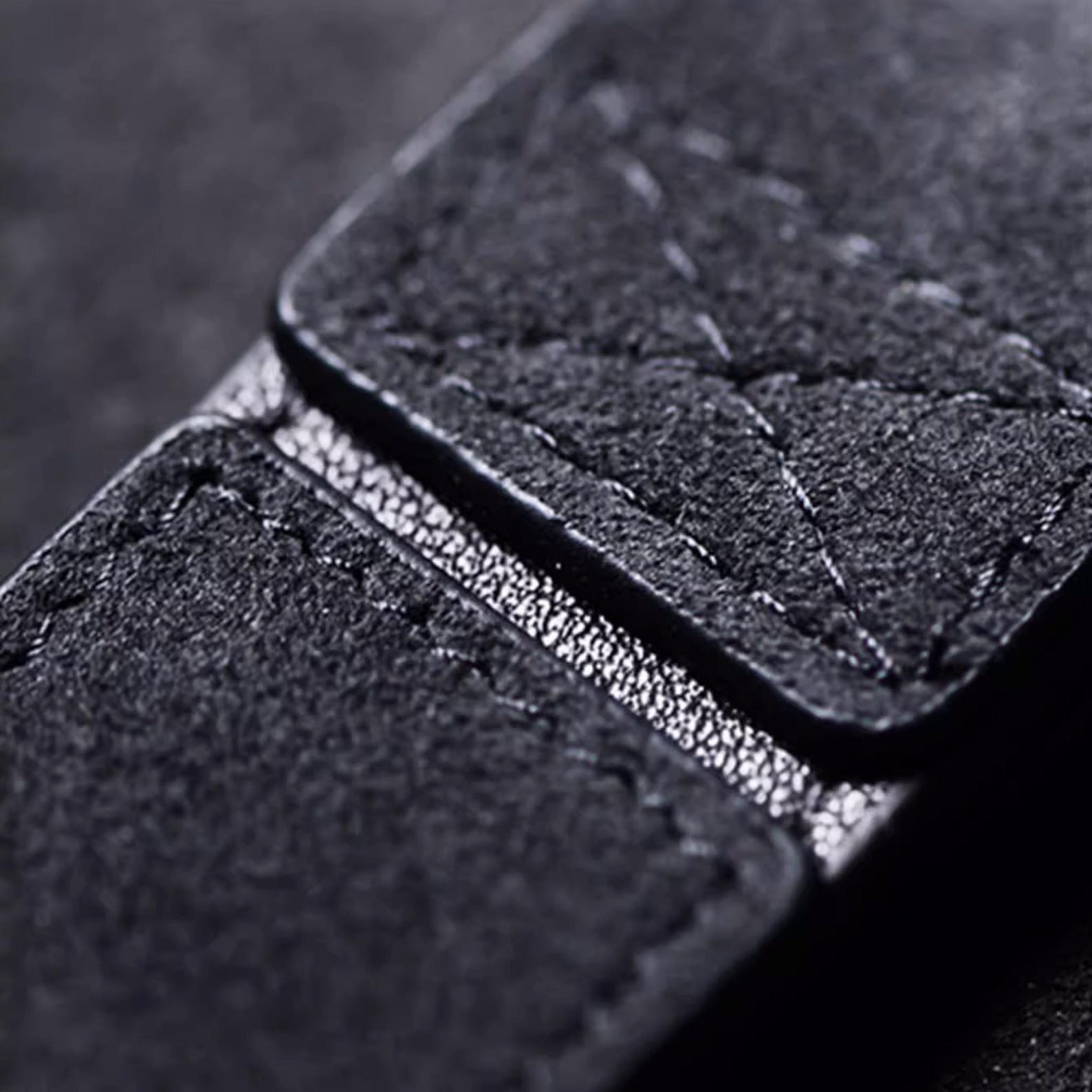 Luxury Alcantara leather car logo keychain on a wooden surface