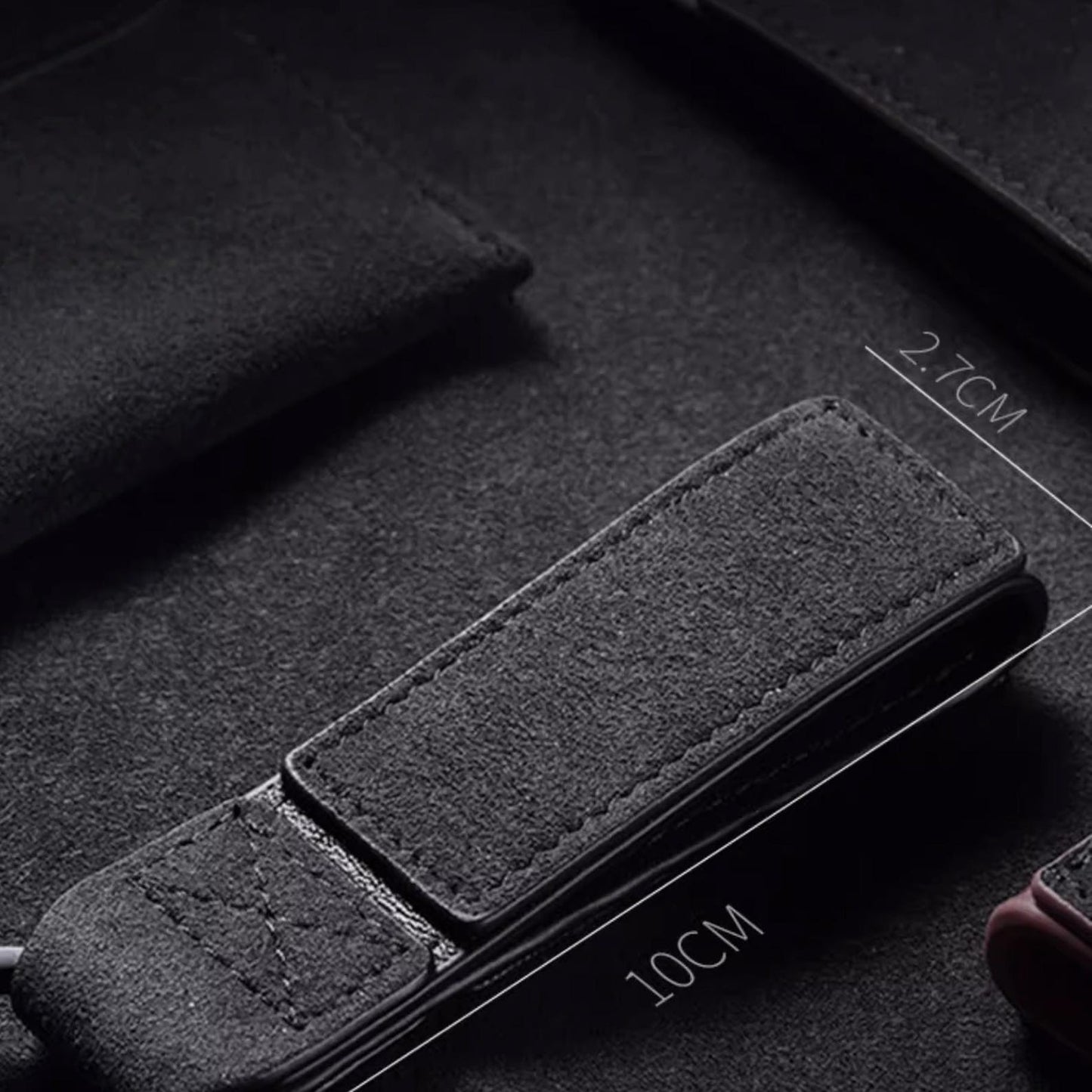 Luxury Alcantara leather car logo keychain on a wooden surface