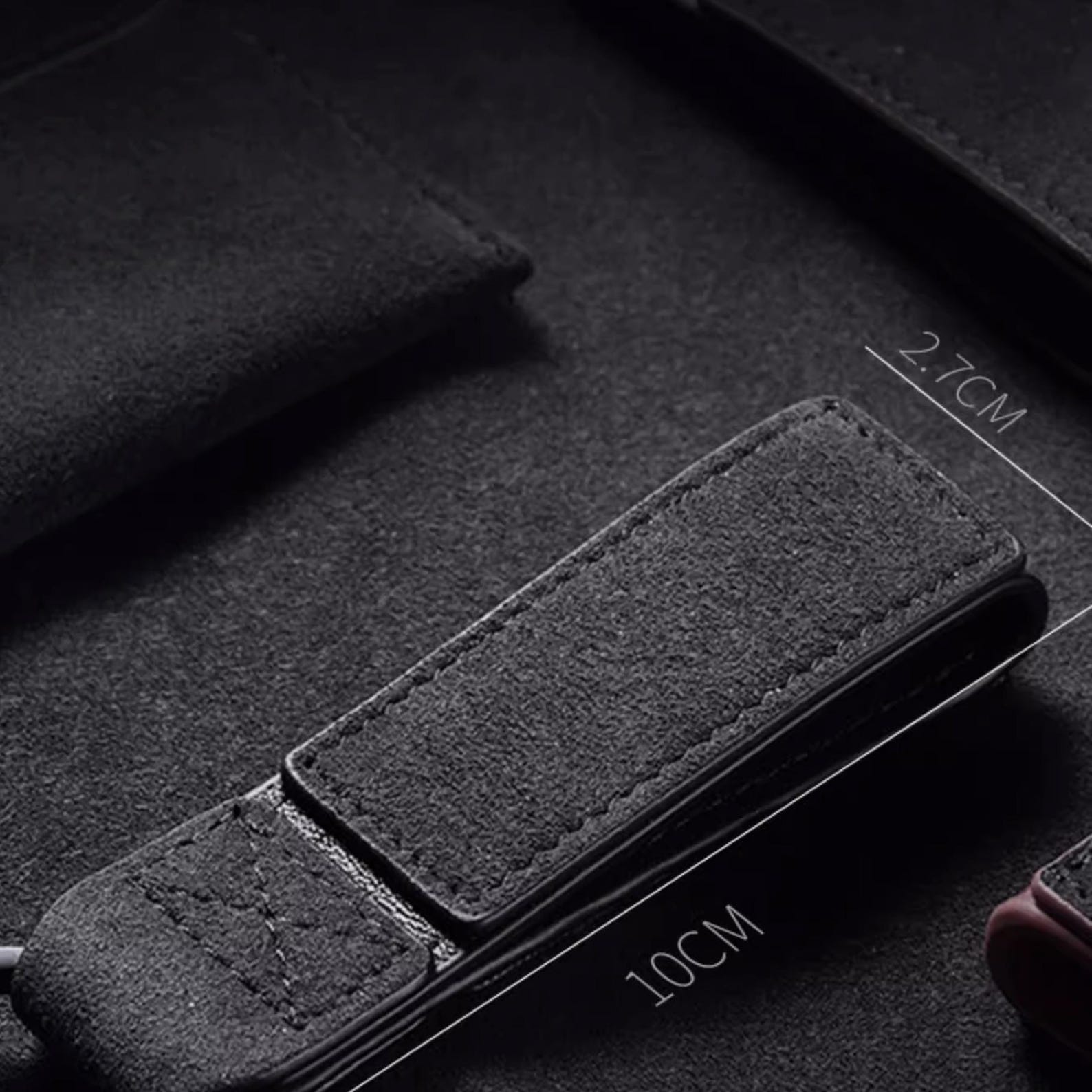 Luxury Alcantara leather car logo keychain on a wooden surface